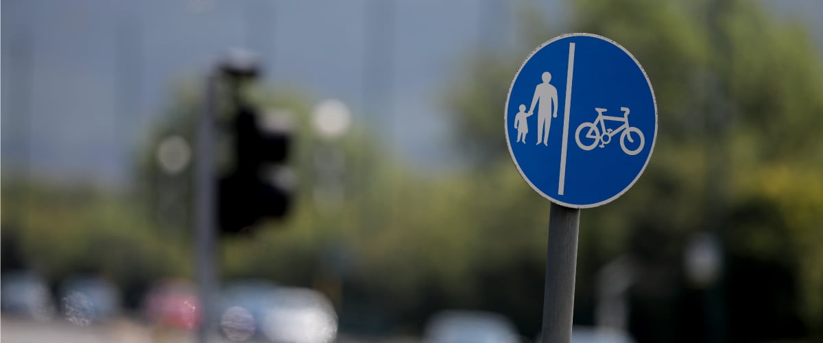 Blue pedestrian and cyclist circle sign on a road with blurred background