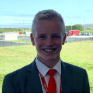 a teenage boy with blonde hair smiling at camera wearing a blazer, white shirt and red tie