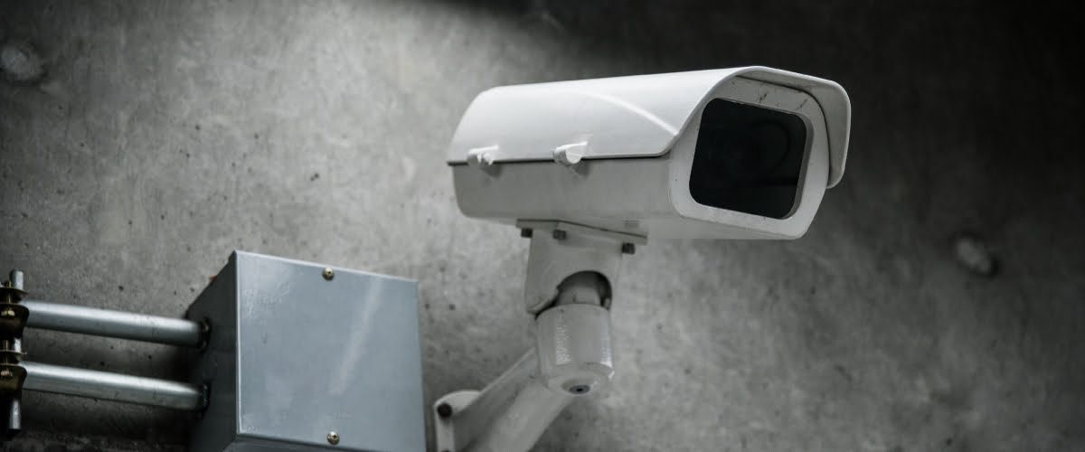 white cctv camera on a wall