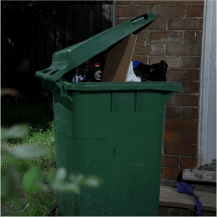 overflowing wheelie bin outside property 