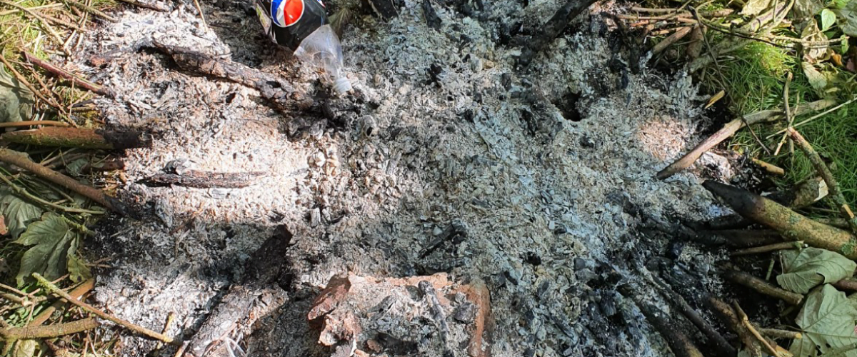 Burnt rubbish including a pepsi max can with remains on the ground