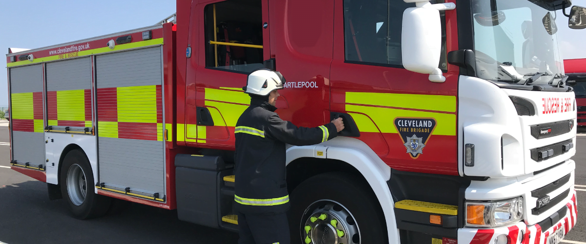 firefighter opening door of fire engine