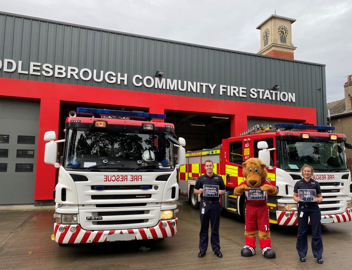 Firefighters and MFC mascot roary the lion stood outside Middlesbrough Fire station holding key safety messages.