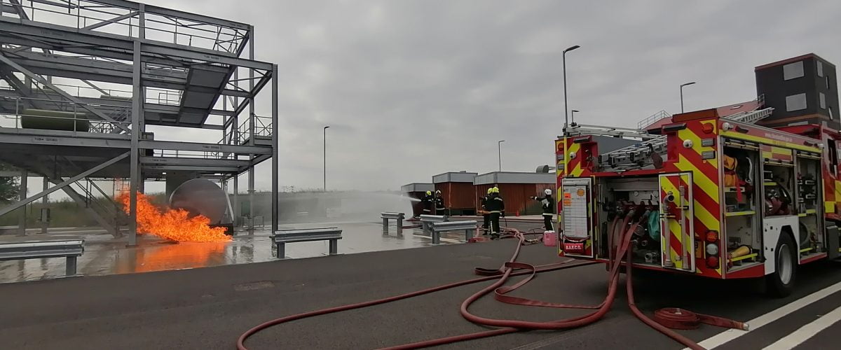 Fireground training with fire, firefighters and fire engine.