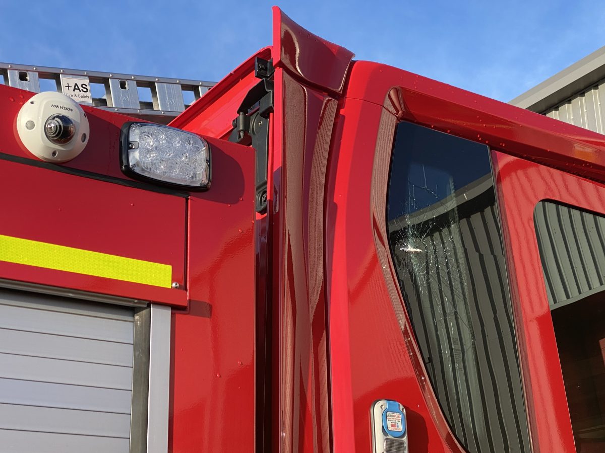 Image shows a red fire engine with a cracked window