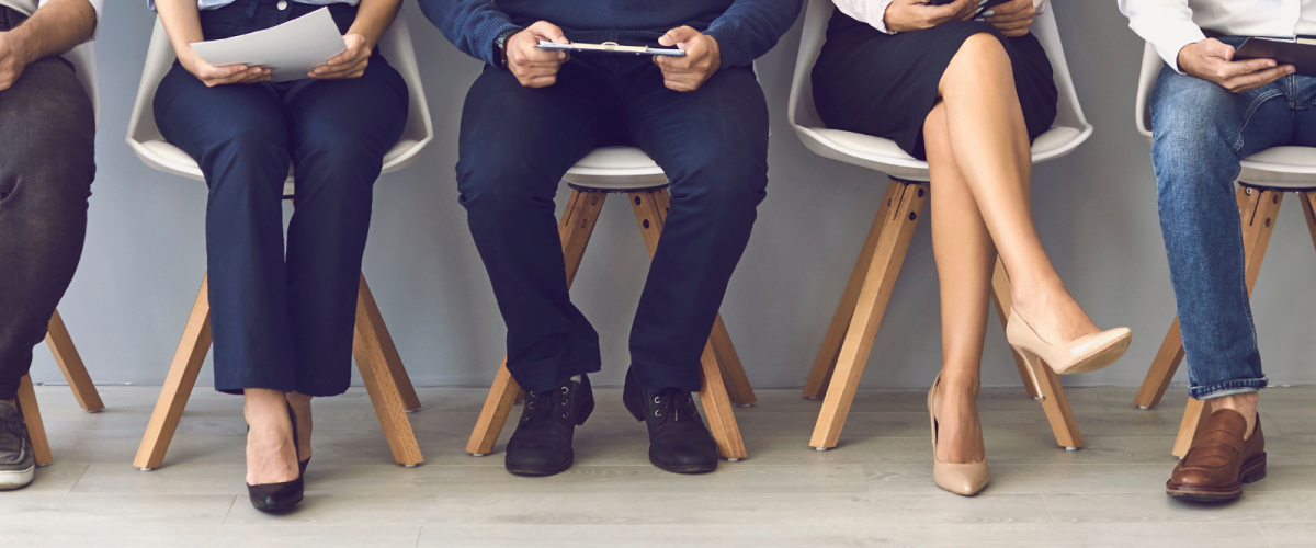 five people dressed in office attire sat on chairs