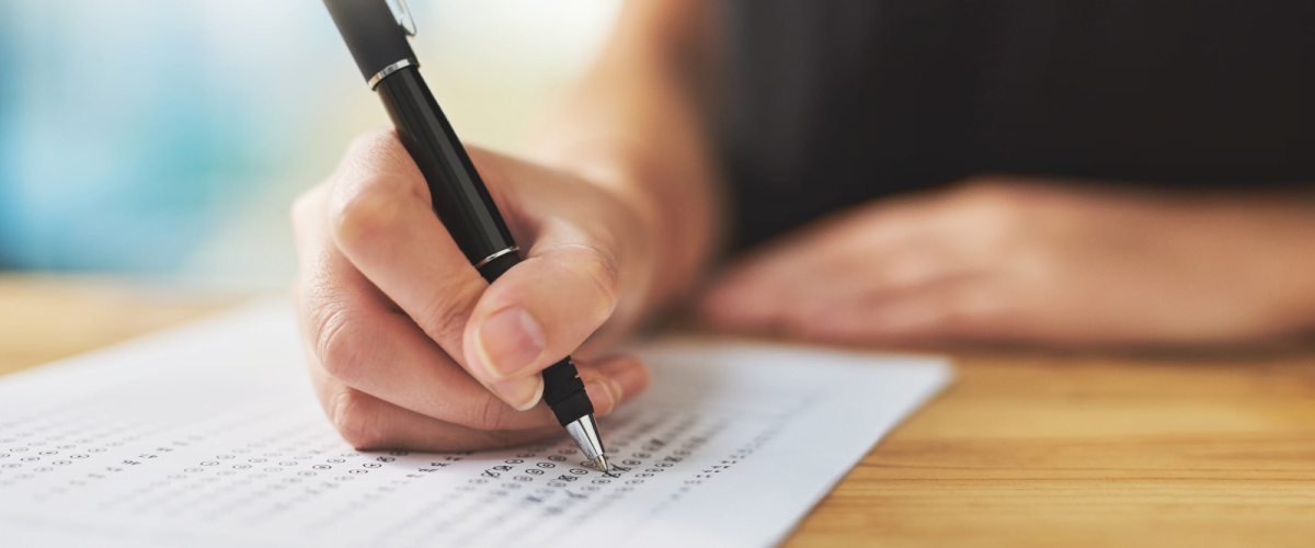 a person at a desk holding a plan completing an assessment