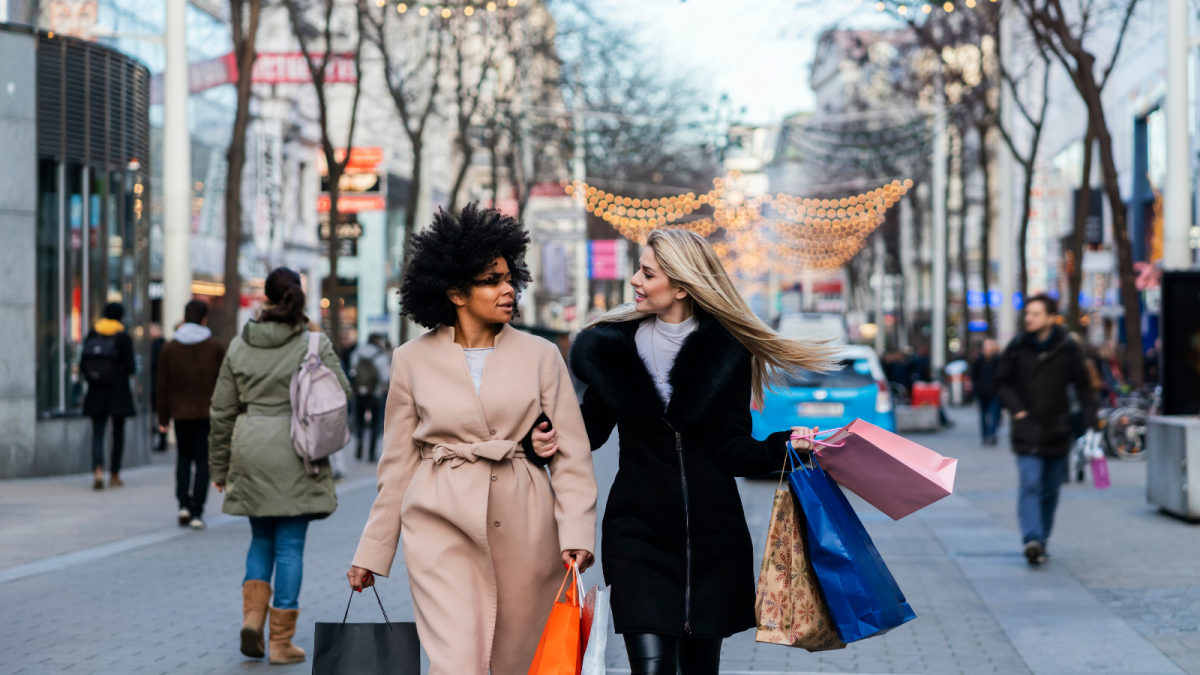 Two ladies Christmas shopping on a busy street