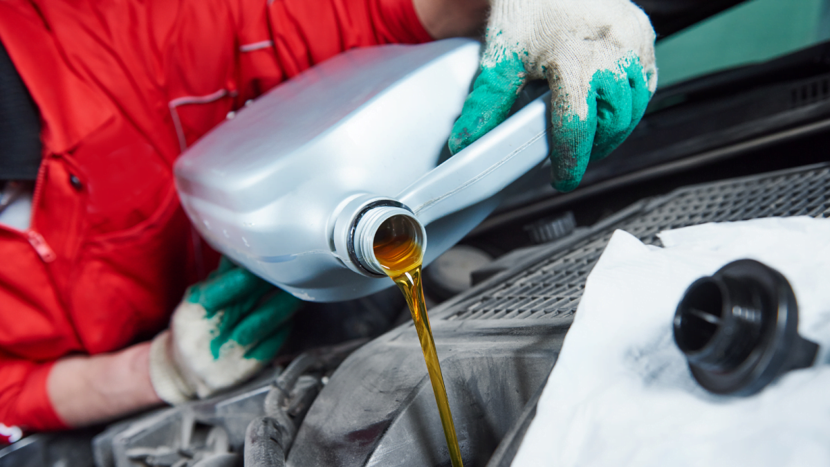 A person holding an oil can filling up the car