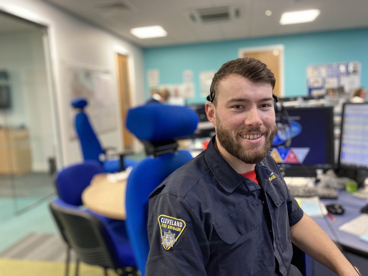 A photo of a man sat at his desk in Fire Control smiling