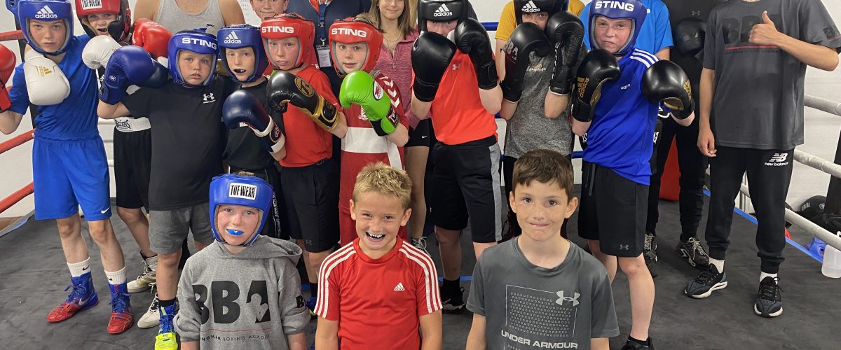 a group of young children in a boxing ring looking towards the camera