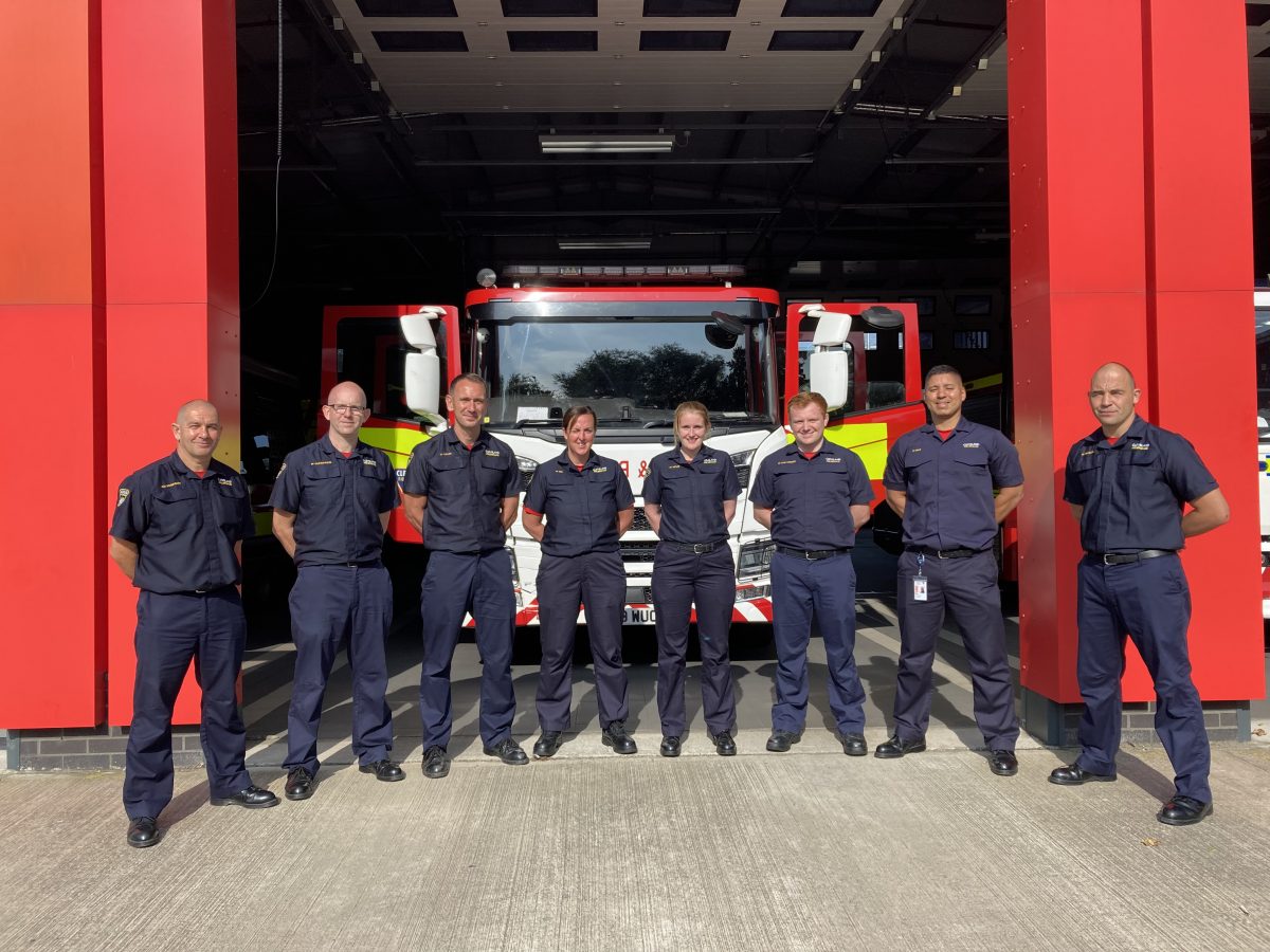 A group of Firefighters stood in a line outside the fire station