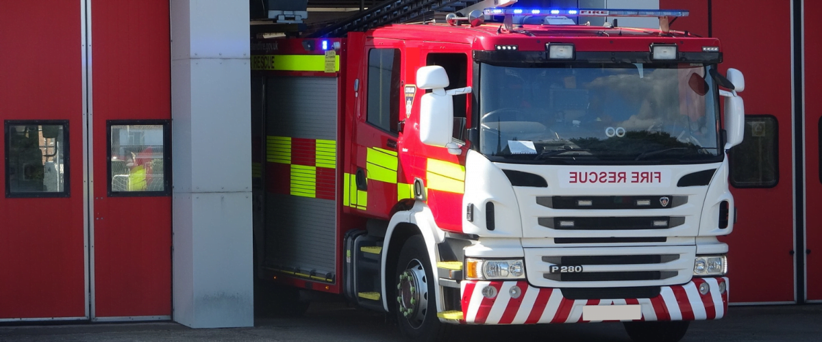 An image of a fire engine emerging from the station