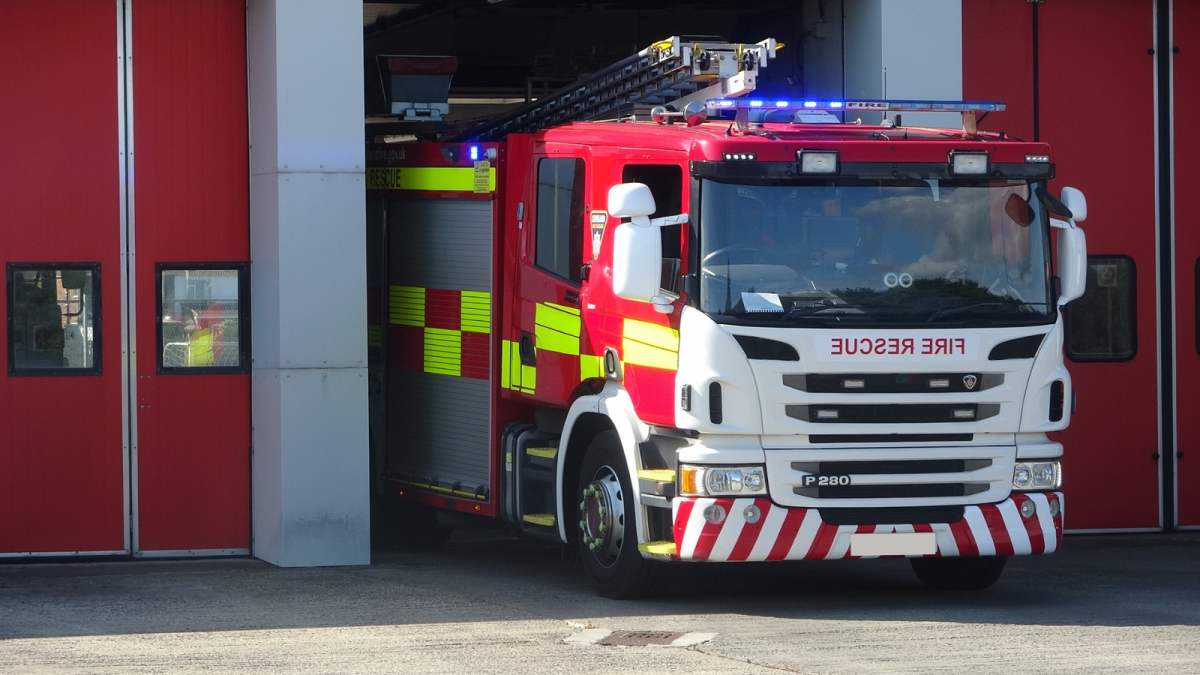An image of a fire engine emerging from the station