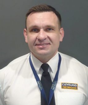 A headshot of Dave Preston in Brigade uniform smiling at camera.