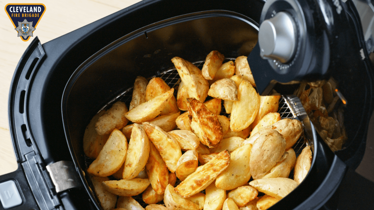 A close up picture of an Air Fryer that has chopped potatoes inside.
