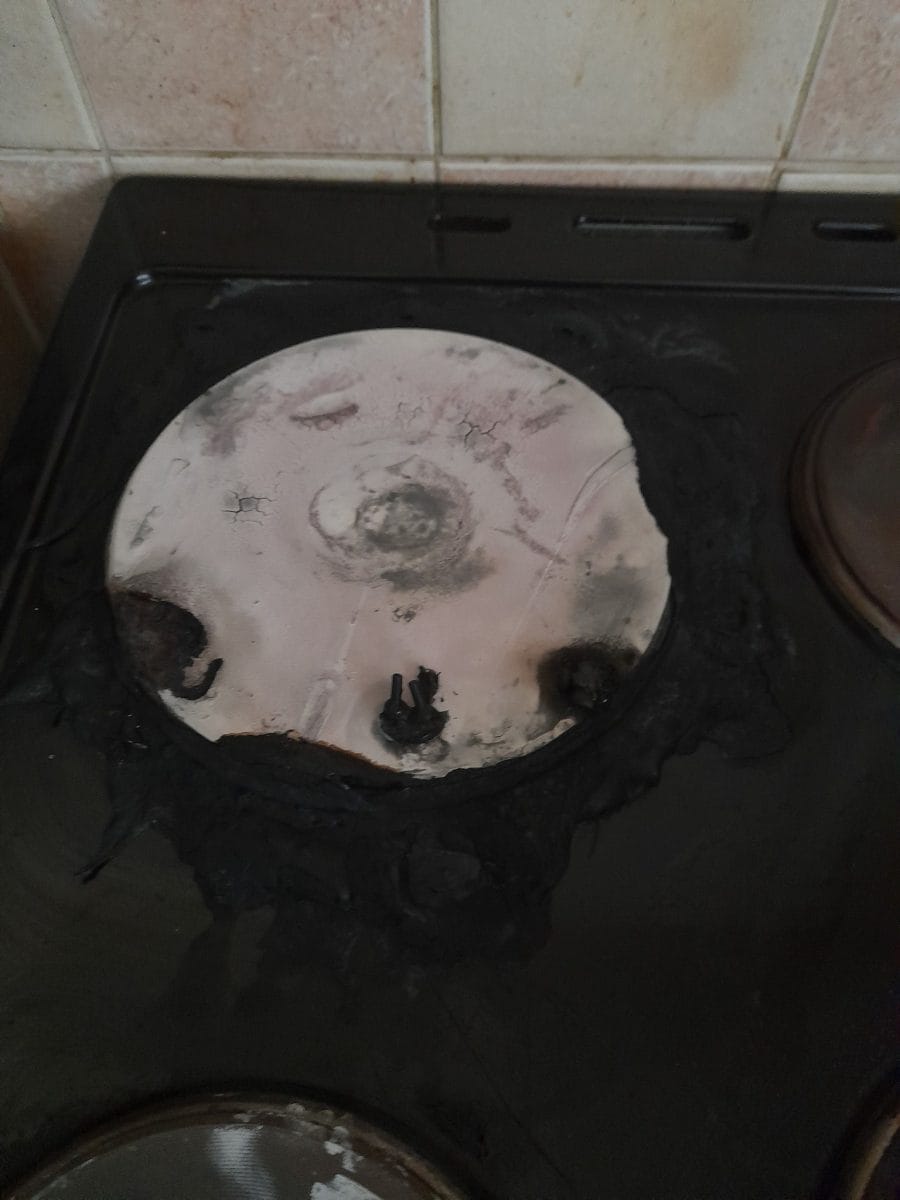 An inside image in a kitchen of a hob on a black oven, the hob has been burnt out.