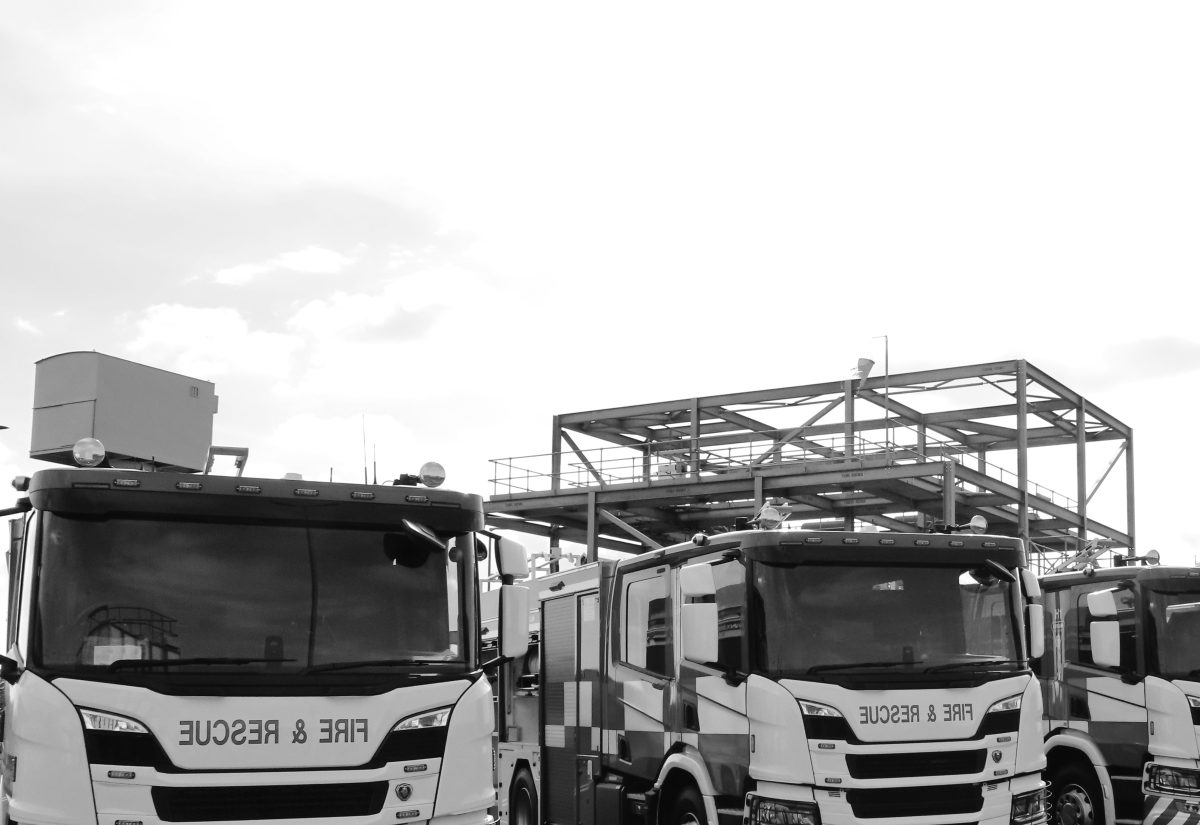 A picture of three fire engines on a training ground in black and white.