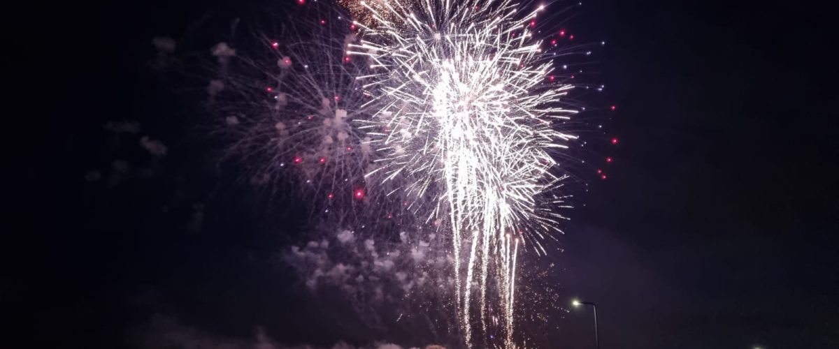 A crowd watching an organised fireworks display